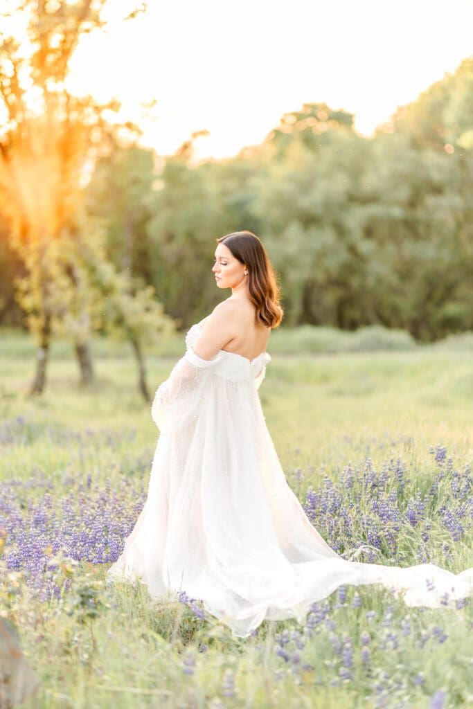 Pregnant mother standing in a lupine field during an El Dorado Hills maternity session at sunset