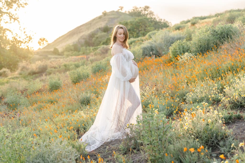 Expecting mom in a white gown in Walnut Creek poppy field
